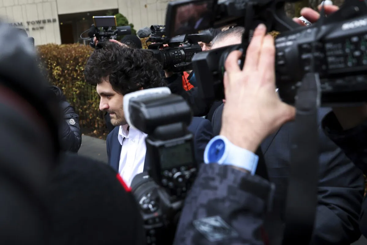 FTX founder Sam Bankman-Fried (C) is escorted to his car from the U.S. District Court in Manhattan in New York on Dec. 22, 2022. (Julia Nikhinson/AP Photo)