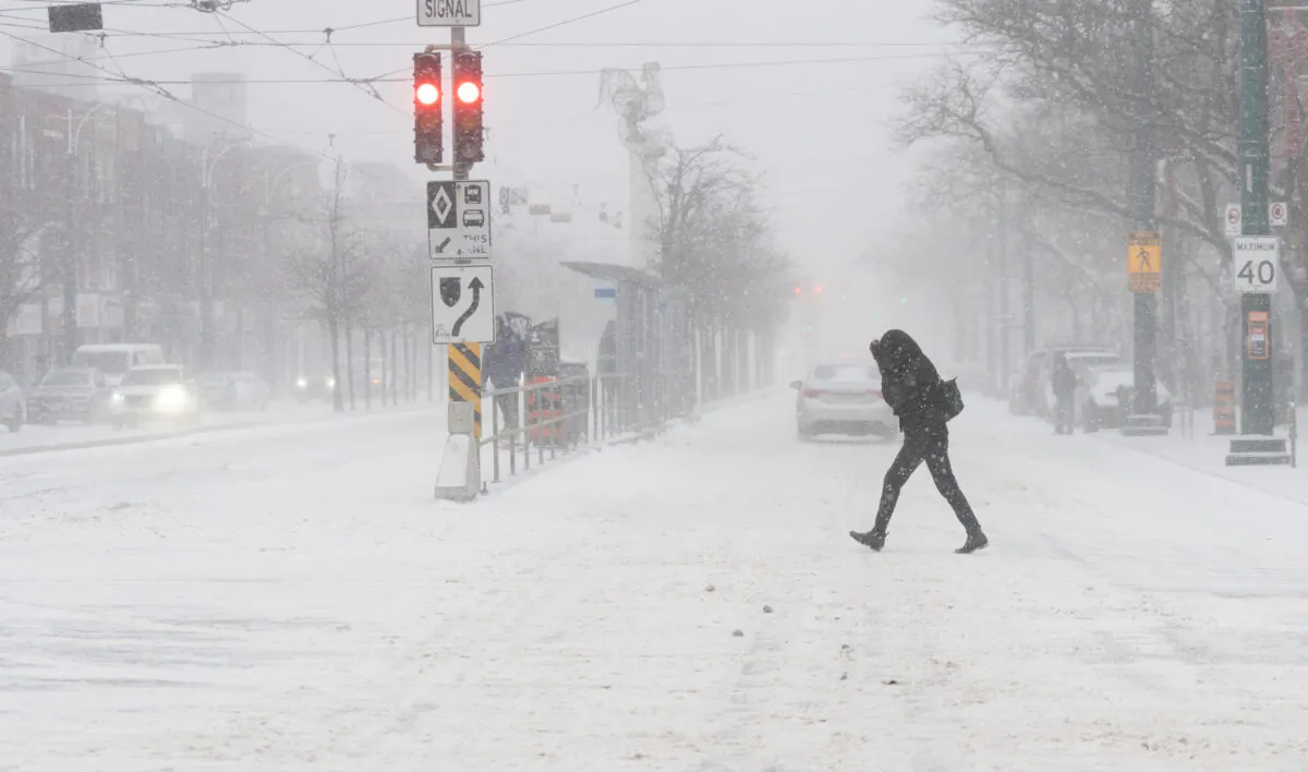 A person walks through blowing snow during a snowstorm in Toronto on Dec. 23, 2022. (Arlyn McAdorey/The Canadian Press)