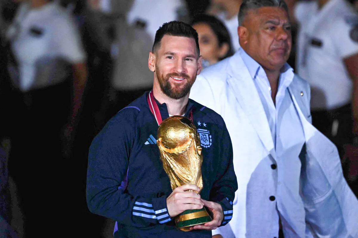 Argentina's captain and star striker, Lionel Messi, holds the FIFA World Cup Trophy upon arrival at Ezeiza International Airport in Buenos Aires on Dec. 20, 2022, after winning the 2022 soccer World Cup in Qatar. (Luis Robayo/AFP via Getty Images)