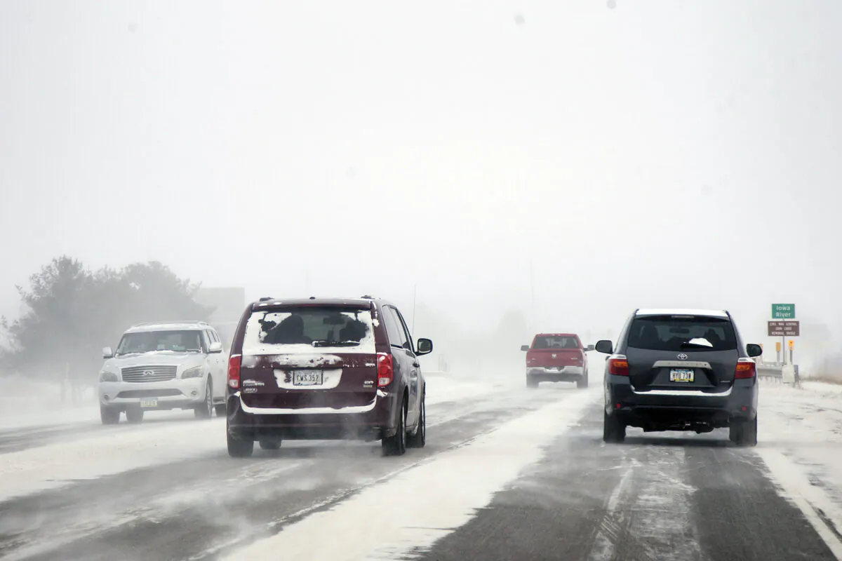 Snow blows across U.S. Highway 6 as vehicles drive during a blizzard warning in Iowa City, Iowa, on Dec. 23, 2022. (Joesph Cress/Iowa City Press-Citizen via AP)