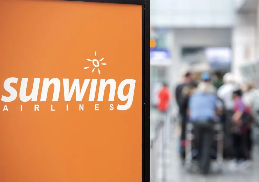 Travellers wait in line at a Sunwing Airlines check-in desk at Trudeau Airport in Montreal, in a file photo. (Graham Hughes/The Canadian Press)