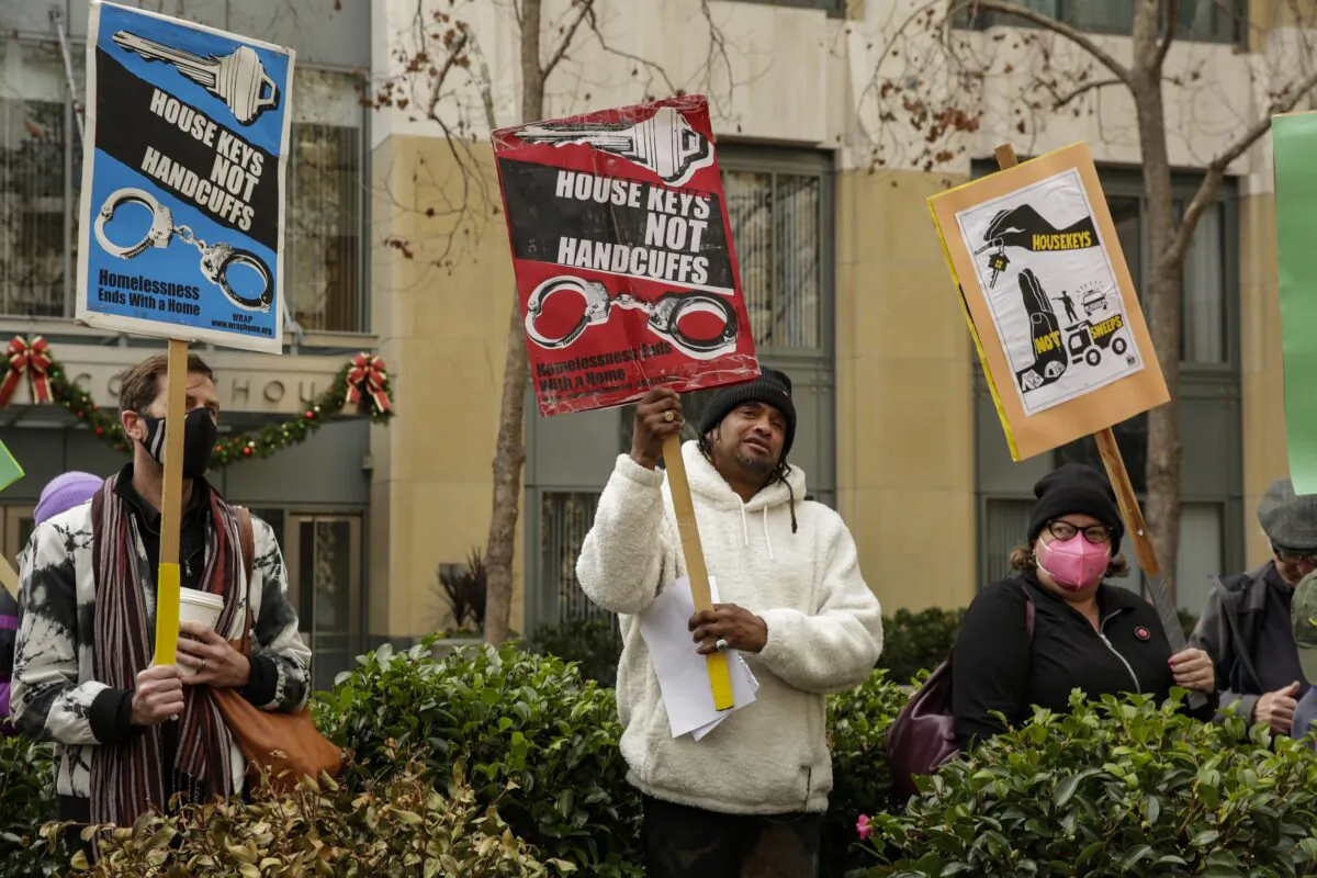 Supporters hold signs at a news conference held by the Coalition on Homelessness at the front steps of Oakland's federal courthouse in Oakland, Calif., on Dec. 22, 2022. (Salgu Wissmath/San Francisco Chronicle via AP)