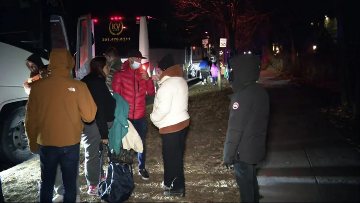 Illegal immigrant families get on to a bus to transport them from near Vice President Kamala Harris's residence to an area church after they arrived in Washington on Dec. 24, 2022. (WJLA via AP)