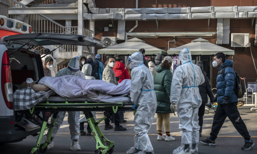 Medical workers wear PPE as they arrive with a patient on a stretcher at a fever clinic in Beijing, China, on Dec. 9, 2022. As part of a 10 point directive, China’s government announced Wednesday that people with COVID-19 who have mild or no symptoms will be permitted to quarantine at home instead of at a government facility, testing requirements are reduced, people are permitted to buy over the counter medications, and local officials can no longer lock down entire neighborhoods or cities, a major shift in its zero COVID policy. (Kevin Frayer/Getty Images)