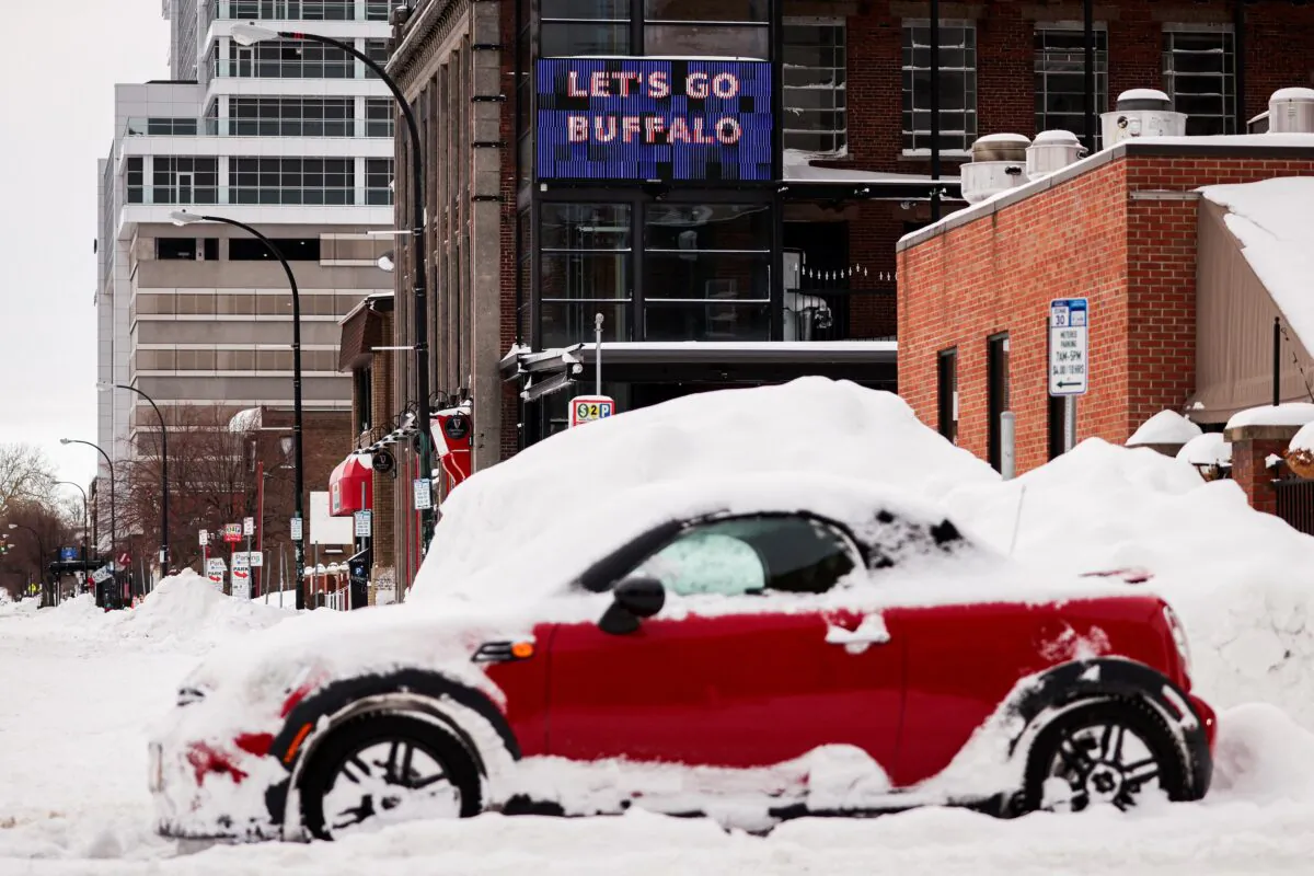 A "let’s go Buffalo" sign behind an abandoned car on the road following a winter storm in Buffalo, N.Y., on Dec. 27, 2022. (Lindsay DeDario/Reuters)