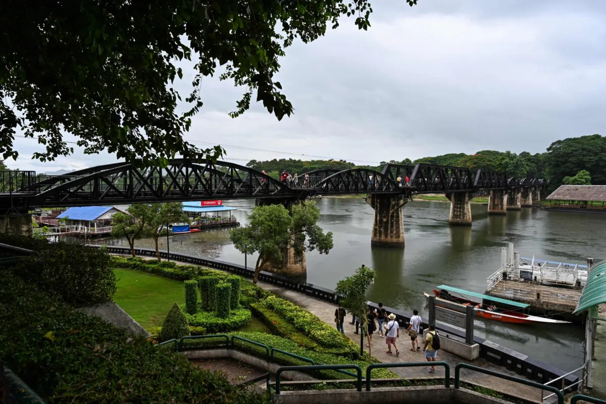 Tourists walk near the railroad bridge over the Kwai Yai River in Kanchanaburi, Thailand, on July 5, 2019. (Jewel Samad/AFP via Getty Images)