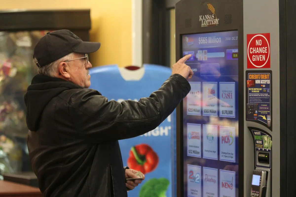David Peralta buys a Mega Millions ticket at a Kansas Lottery machine in a Dillons grocery, in Topeka, Kan., on Dec. 27, 2022. (John Hanna/AP Photo)