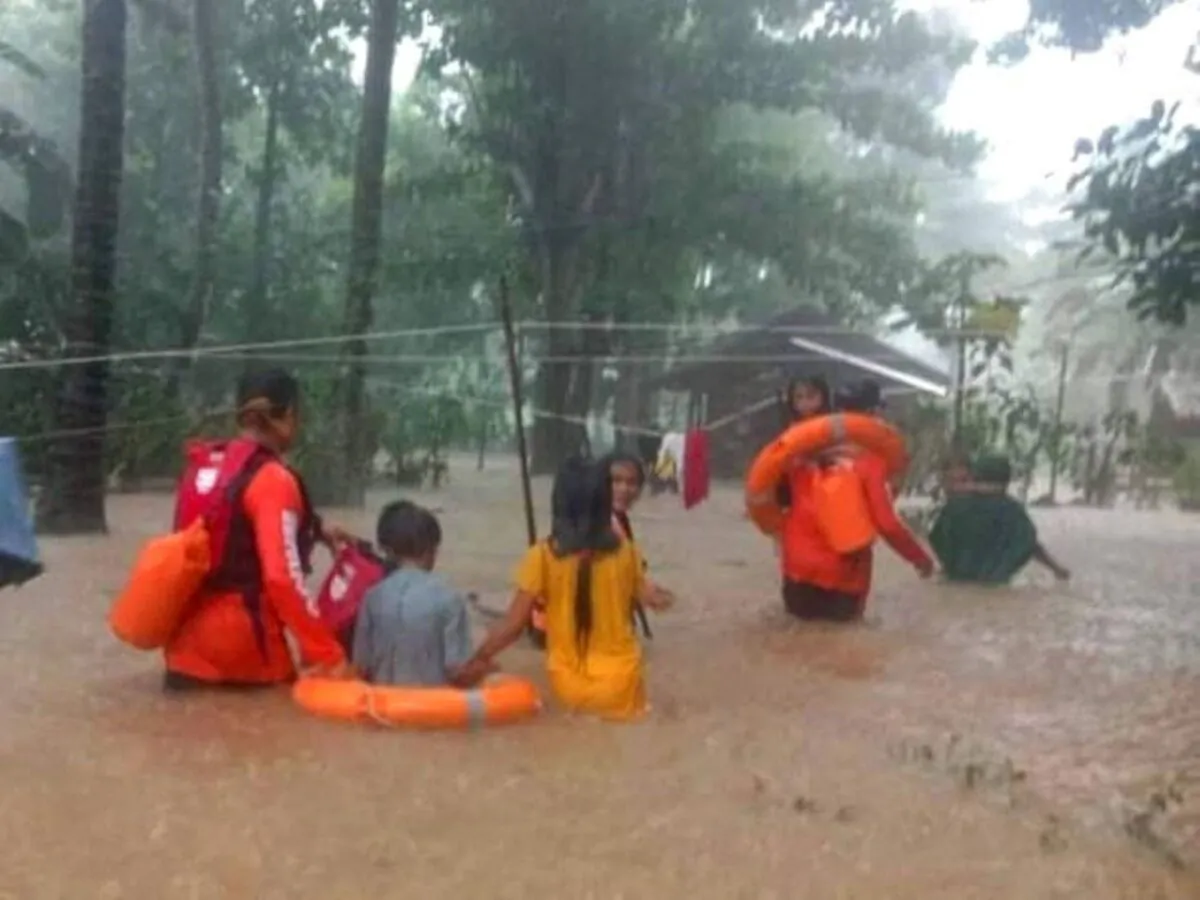 Rescue workers help people affected by floods, in Plaridel, Misamis Occidental Province, Philippines, on Dec. 26, 2022. (Philippine Coast Guard/Handout via Reuters)