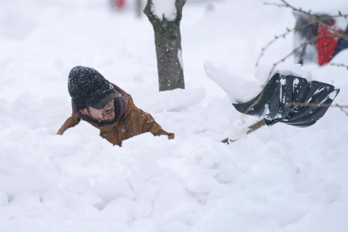Tommy Roetzer digs out his driveway on West Delavan Street in Buffalo, N.Y., on Dec. 26, 2022. (Derek Gee/The Buffalo News via AP)