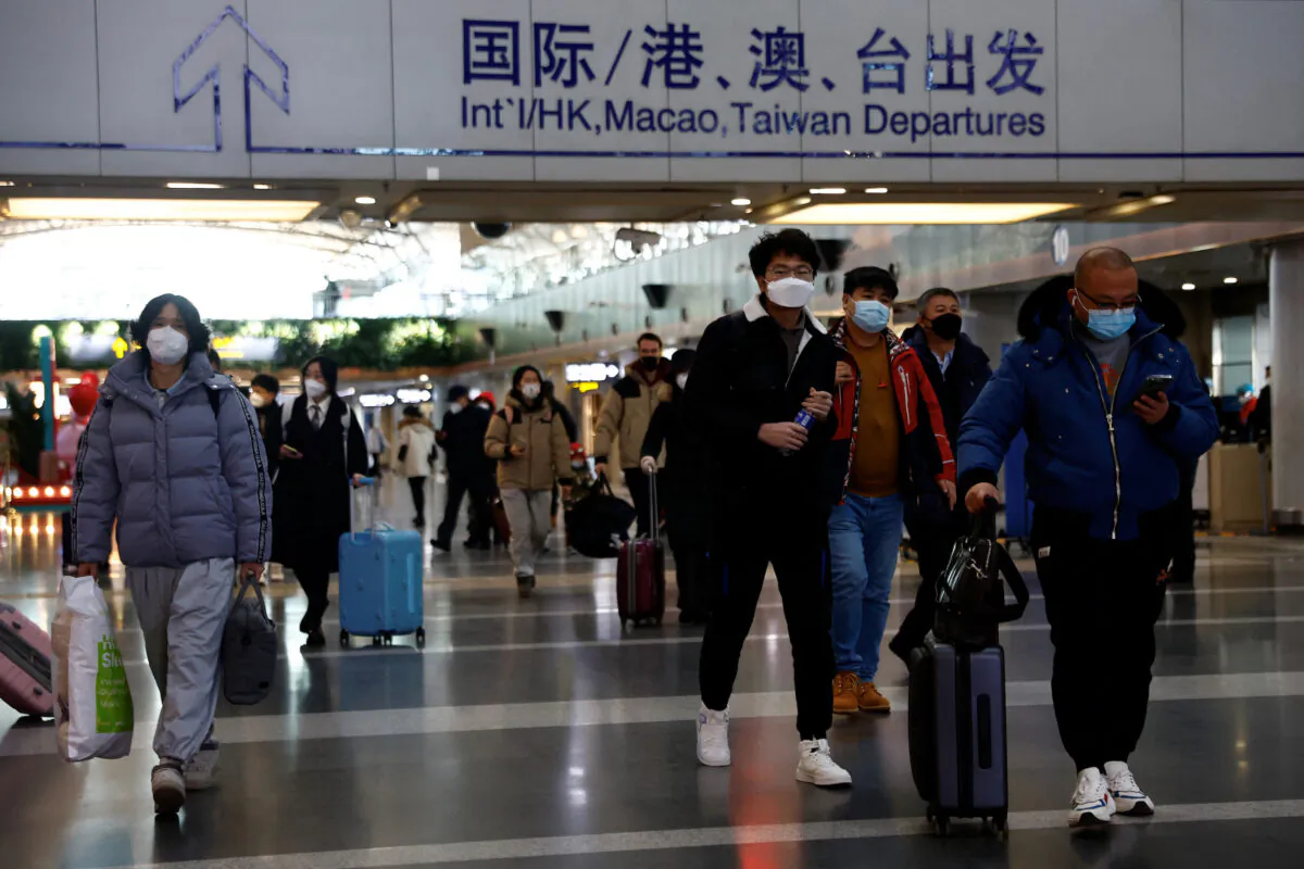 Travellers walk with their luggage at Beijing Capital International Airport, amid the COVID-19 outbreak in Beijing, China, on Dec. 27, 2022. (Tingshu Wang/Reuters)