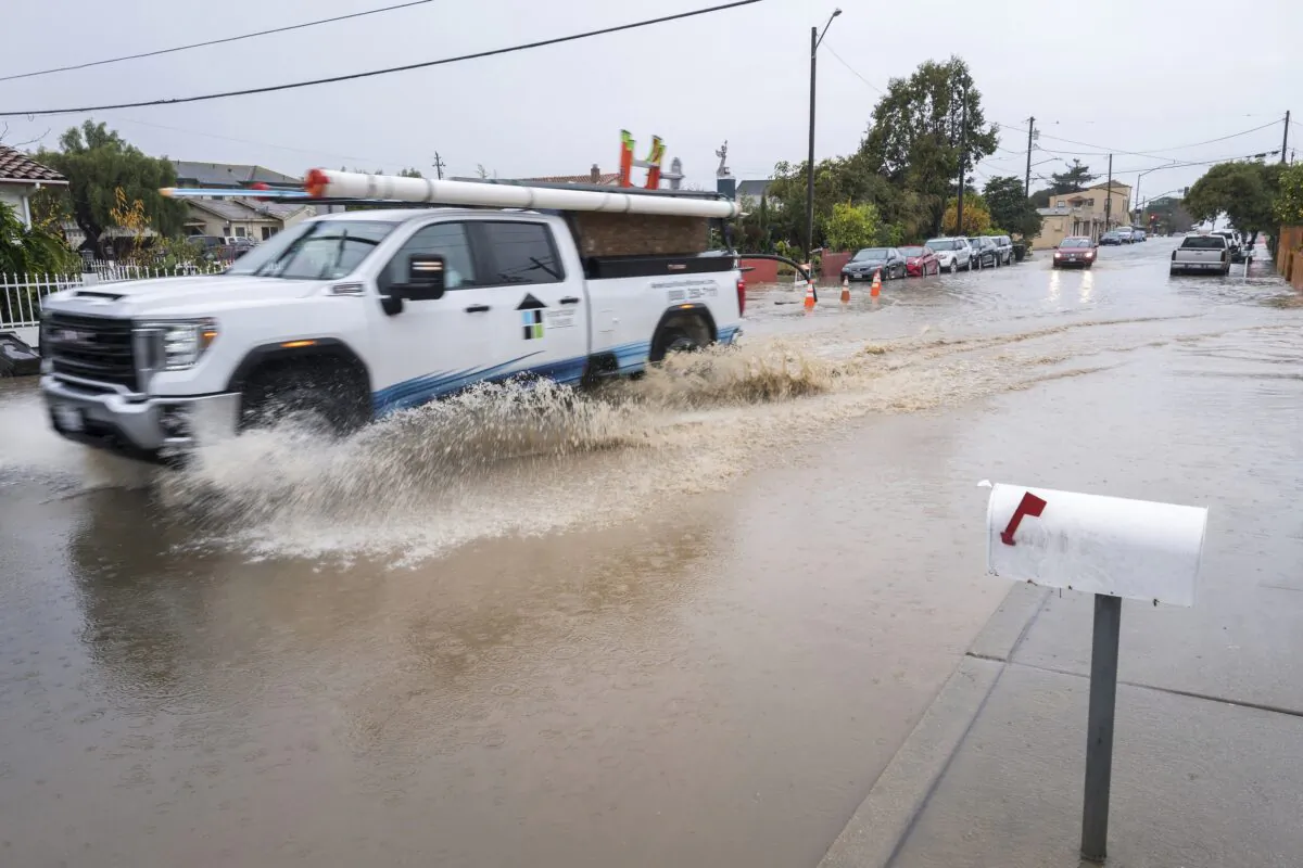 A truck drives through a flooded intersection of E Bolivar Street in Salinas, Calif., on Dec. 27, 2022. (Nic Coury/AP Photo)
