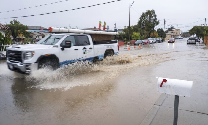 A truck drives through a flooded intersection of E Bolivar Street in Salinas, Calif., on Dec. 27, 2022. (Nic Coury/AP Photo)