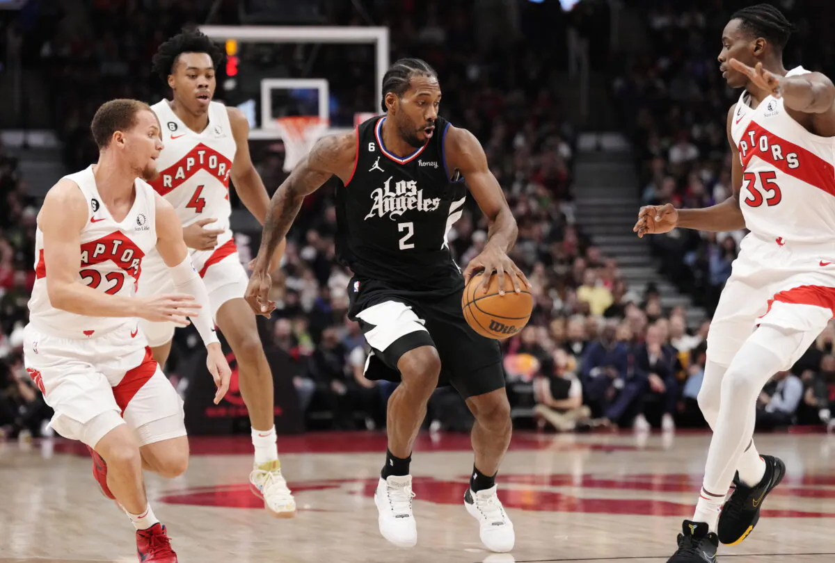 Los Angeles Clippers forward Kawhi Leonard (2) is defended by Toronto Raptors guard Malachi Flynn (22), forward Scottie Barnes (4) and center Christian Koloko (35) during the first half of an NBA basketball game in Toronto on Dec. 27, 2022. (Frank Gunn/The Canadian Press via AP)