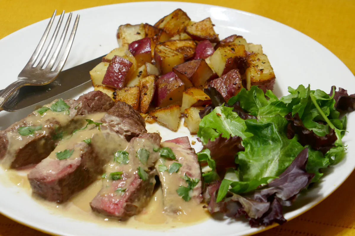 Brandy Flambeed Steak with Garlic Potatoes. (Linda Gassenheimer/TNS)