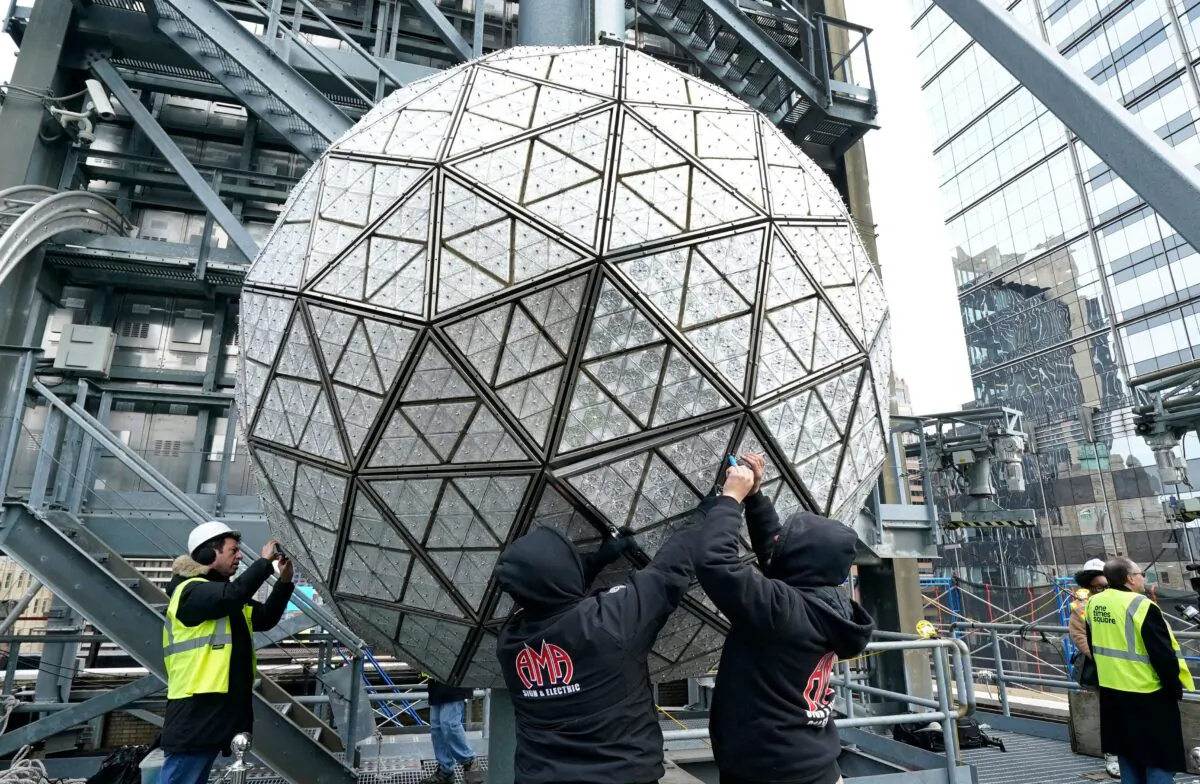 Workers install some of the 192 sparkling new Waterford Crystal Triangles on the Times Square New Year's Eve Ball atop the roof of One Times Square in New York on Dec. 27, 2022.(Timothy A. Clary/AFP via Getty Images)
