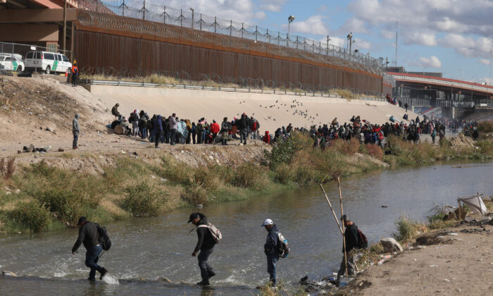 People walk across the Rio Grande to surrender to U.S. Border Patrol agents in El Paso, Texas, as seen from Ciudad Juarez, Mexico, on Dec. 13, 2022. (Herika Martinez/AFP/Getty Images)