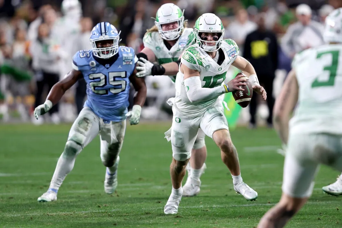 Bo Nix (10) of the Oregon Ducks rushes from the pocket under pressure from Kaimon Rucker (25) of the North Carolina Tar Heels during the second half of the San Diego Credit Union Holiday Bowl game at PETCO Park in San Diego on Dec. 28, 2022. (Sean M. Haffey/Getty Images)