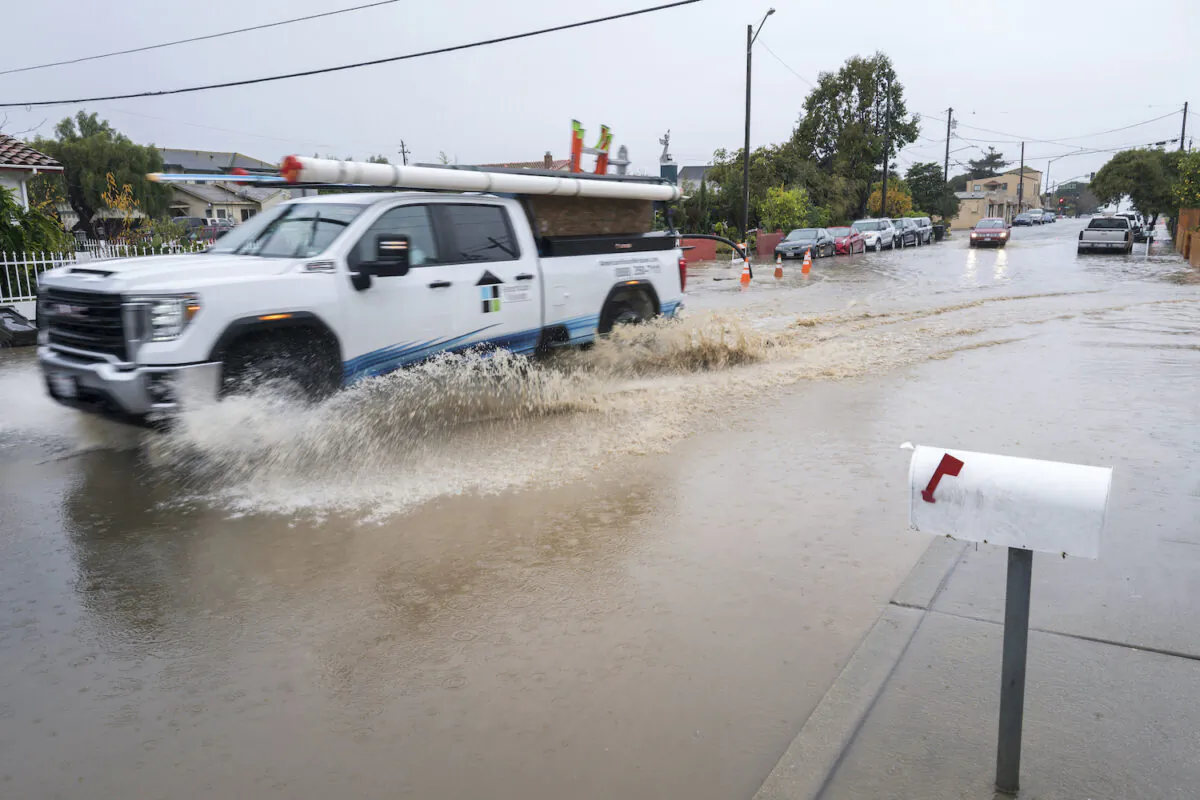 A truck drives through a flooded intersection of E Bolivar Street in Salinas, Calif., Dec. 27, 2022. (Nic Coury/AP Photo)