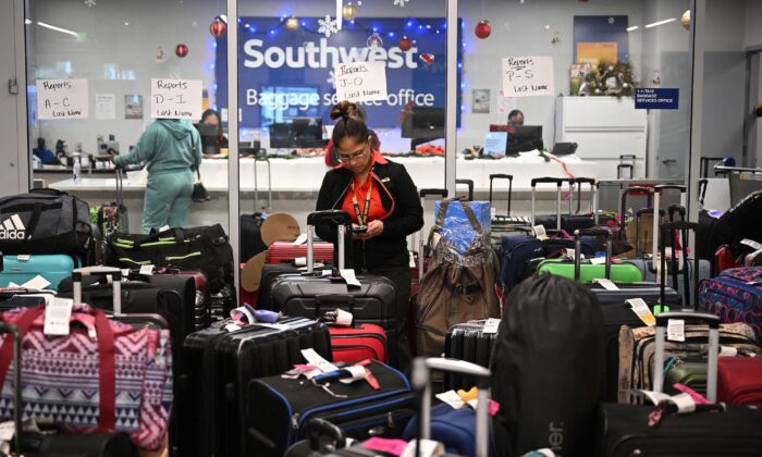 A Southwest Airlines ground crew member organizes unclaimed luggage at the Southwest Airlines luggage area, at Los Angeles International Airport in Los Angeles, Calif., on Dec. 28, 2022. (Robyn Beck/AFP/Getty Images)
