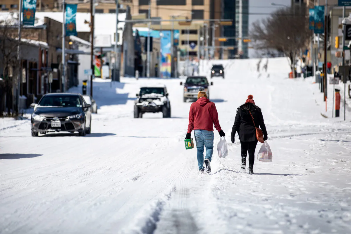 People carry groceries from a local gas station in Austin, Texas, on Feb. 15, 2021. Winter storm Uri brought historic cold weather to Texas, causing traffic delays and power outages. (Montinique Monroe/Getty Images)