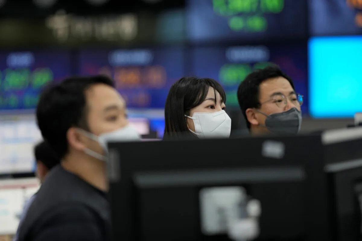 Currency traders stand near the screens showing the foreign exchange rates at a foreign exchange dealing room in Seoul, South Korea, on Dec. 29, 2022. (Lee Jin-man/AP Photo)