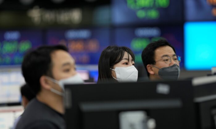 Currency traders stand near the screens showing the foreign exchange rates at a foreign exchange dealing room in Seoul, South Korea, on Dec. 29, 2022. (Lee Jin-man/AP Photo)