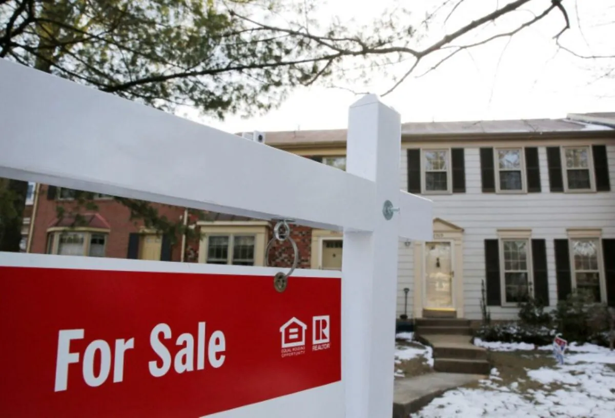 A home for sale sign hangs in front of a house in Oakton, Va., on March 27, 2014. (Reuters)