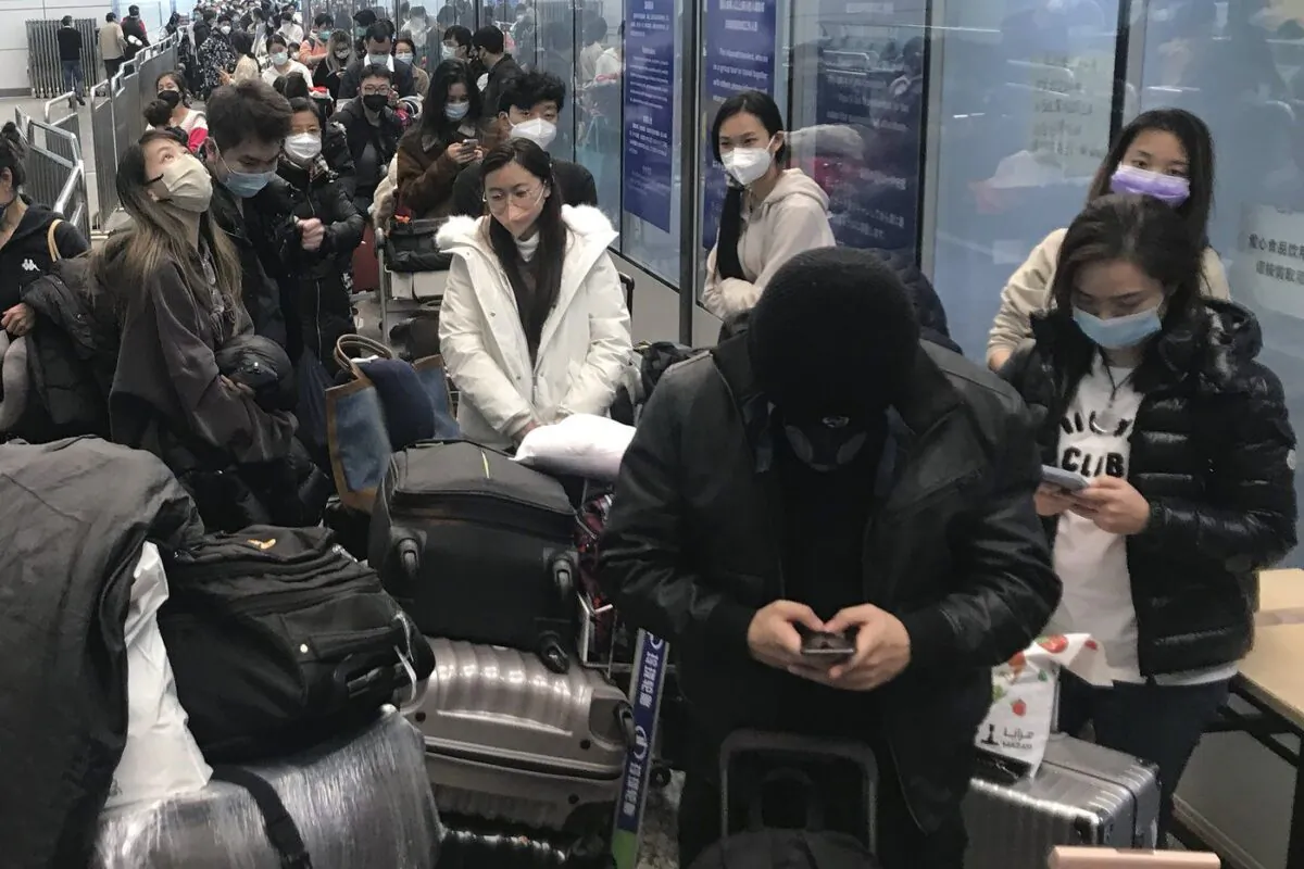 Inbound travelers waiting for hours to board buses to leave for quarantine hotels and facilities from Guangzhou Baiyun Airport in southern China's Guangdong province on Dec. 25 2022. (The Canadian Press/AP, Emily Wang Fujiyama)