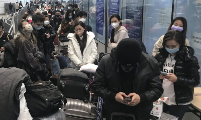 Inbound travelers waiting for hours to board buses to leave for quarantine hotels and facilities from Guangzhou Baiyun Airport in southern China's Guangdong province on Dec. 25 2022. (The Canadian Press/AP, Emily Wang Fujiyama)