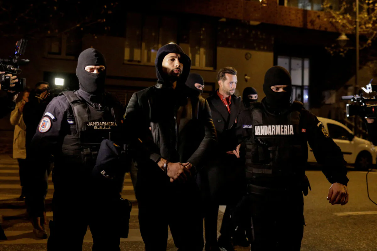 Andrew Tate and Tristan Tate are escorted by police officers outside the headquarters of the Directorate for Investigating Organized Crime and Terrorism in Bucharest (DIICOT) after being detained for 24 hours, in Bucharest, Romania, Dec. 29, 2022. (Inquam Photos/Octav Ganea via Reuters)