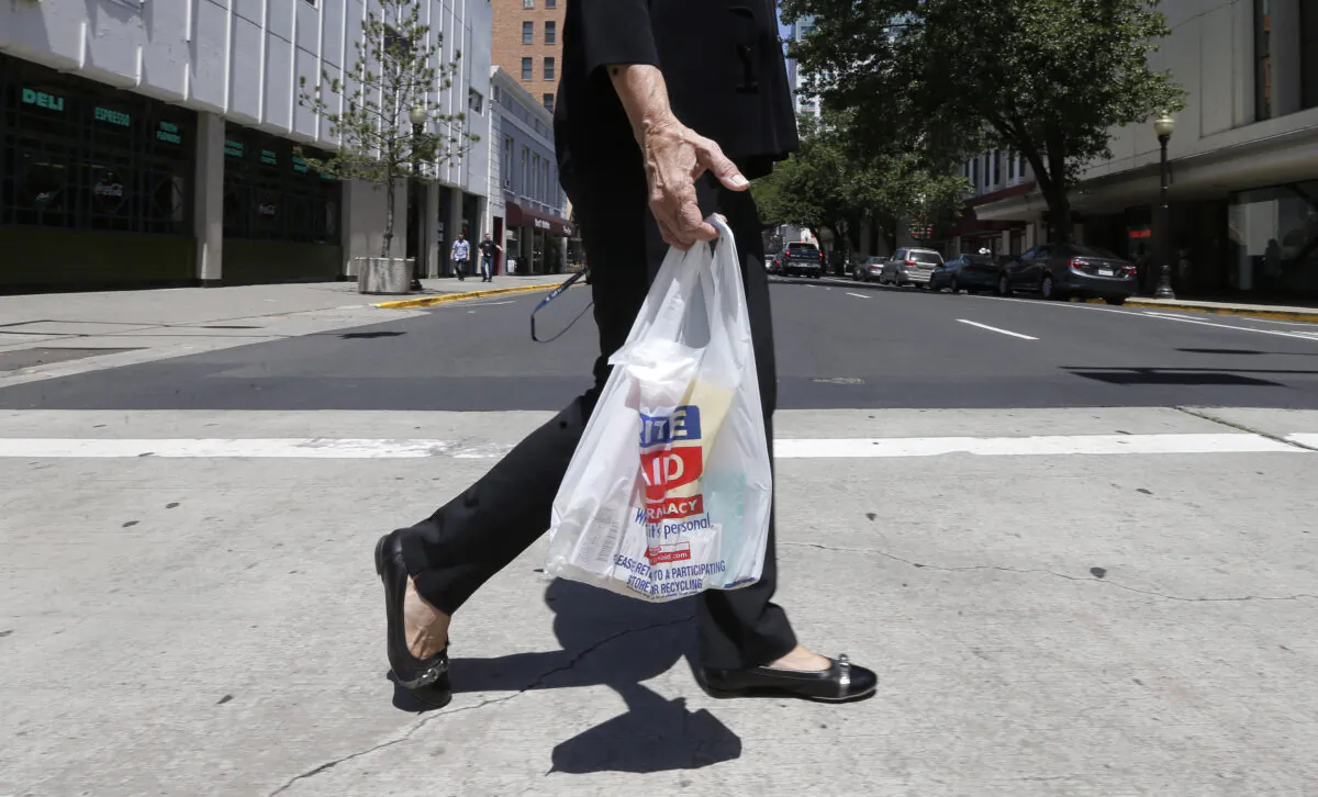 A woman walks with a plastic bag in Sacramento, Calif., on May 14, 2014. (AP Photo, File)