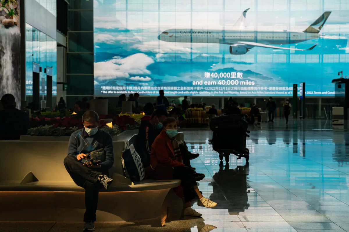 Travelers sit at the arrival hall of the Hong Kong International Airport in Hong Kong on Dec. 30, 2022. (Anthony Kwan/Getty Images)
