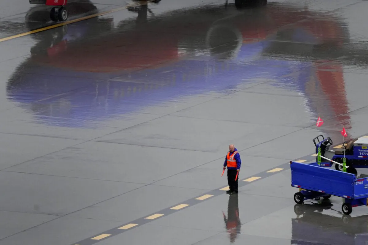 A Southwest Airlines ground operations crew member waits to guide an arriving jet into a gate at Sky Harbor International Airport in Phoenix on Dec. 28, 2022. (Matt York/AP Photo)