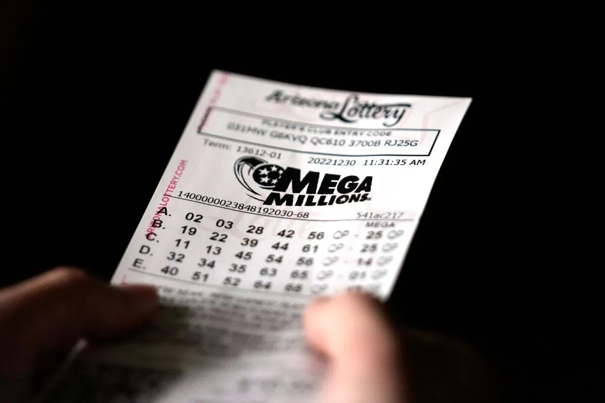 A person holds a Mega Millions lottery ticket in Tempe, Ariz., on Dec. 30, 2022. (Ross D. Franklin/AP Photo)