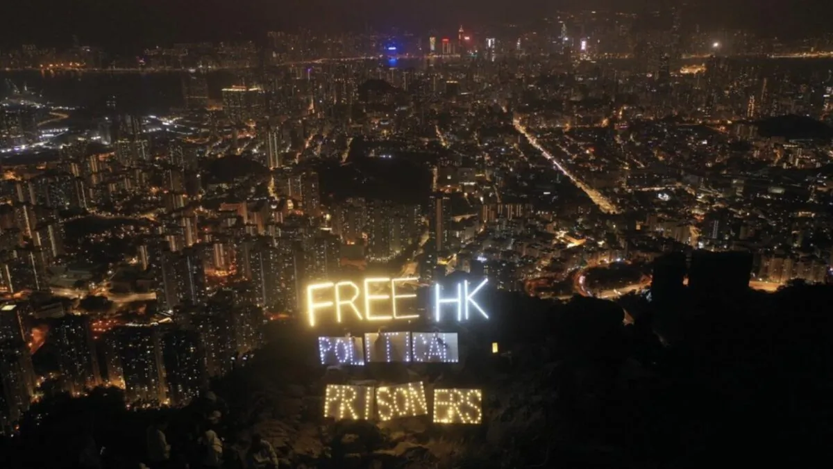 More than a dozen Hong Kong people holding LED luminaires and electronic candles to display the words "Free HK political prisoners" atop Lion Rock in Hong Kong on Dec. 31, 2022. (Hui Tat/The Epoch Times)