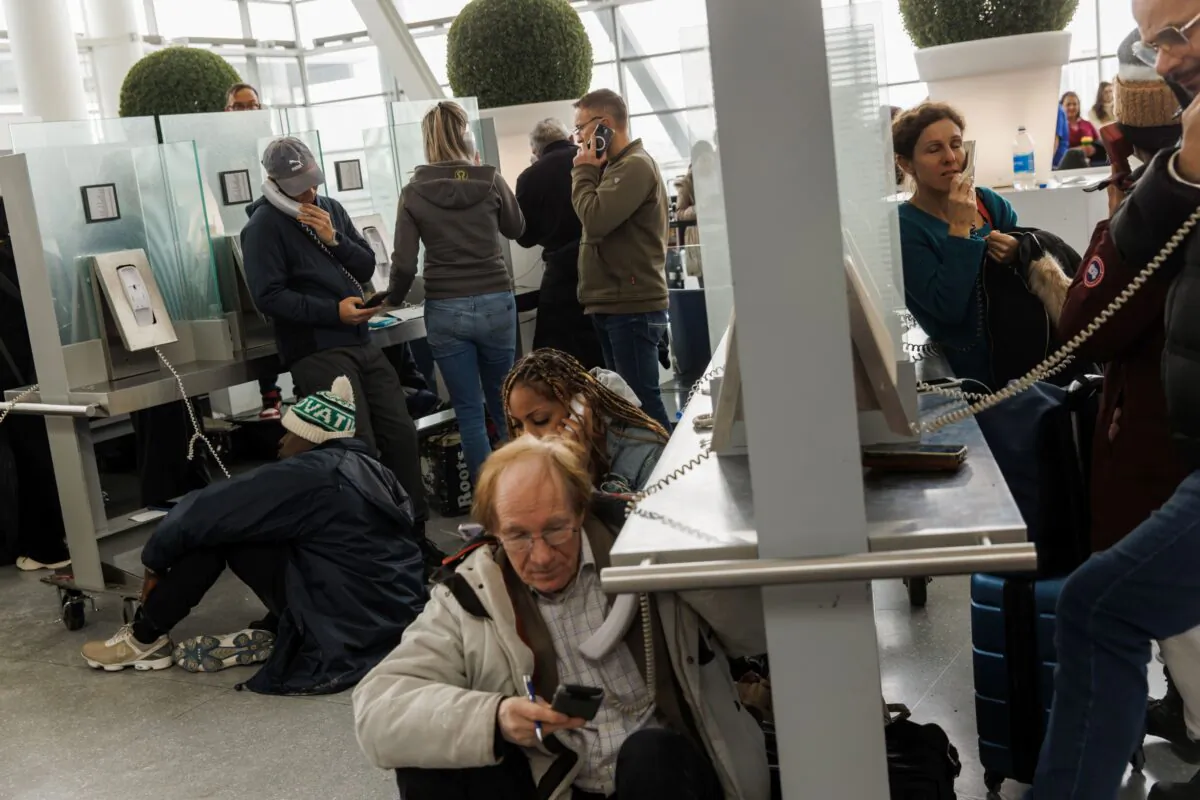 Travellers wait on hold as they try and speak with their respective airlines at Toronto Pearson International Airport, as a major winter storm disrupts flights in and out of the airport on Dec. 24, 2022. (The Canadian Press/Cole Burston)