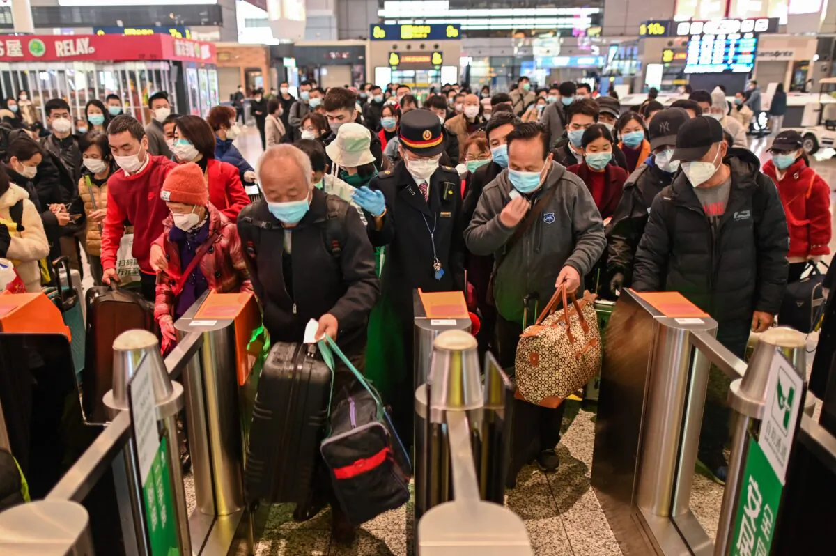 People wearing face masks as a preventive measure against COVID-19 head for a train at a station in Shanghai on March 28, 2020. (Hector Retamal/AFP via Getty Images)