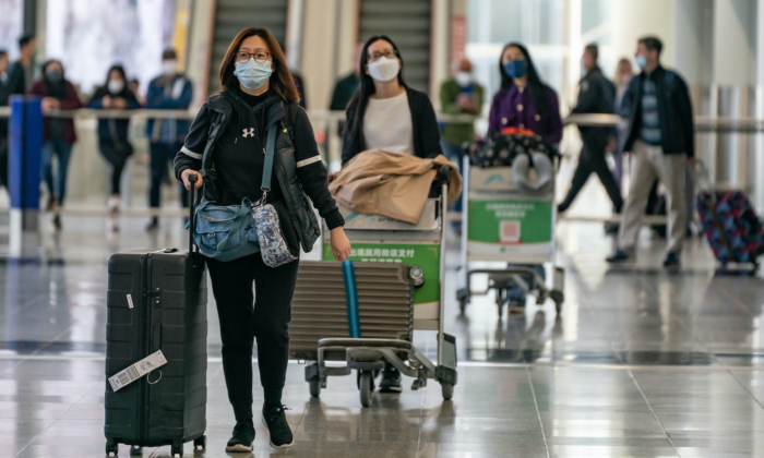 Travellers walk with their luggage at the arrival hall of the Hong Kong International Airport on Dec. 30, 2022. Authorities around the world are imposing or considering curbs on travelers from China as COVID-19 cases there surge following its relaxation of zero-COVID rules. (Anthony Kwan/Getty Images)