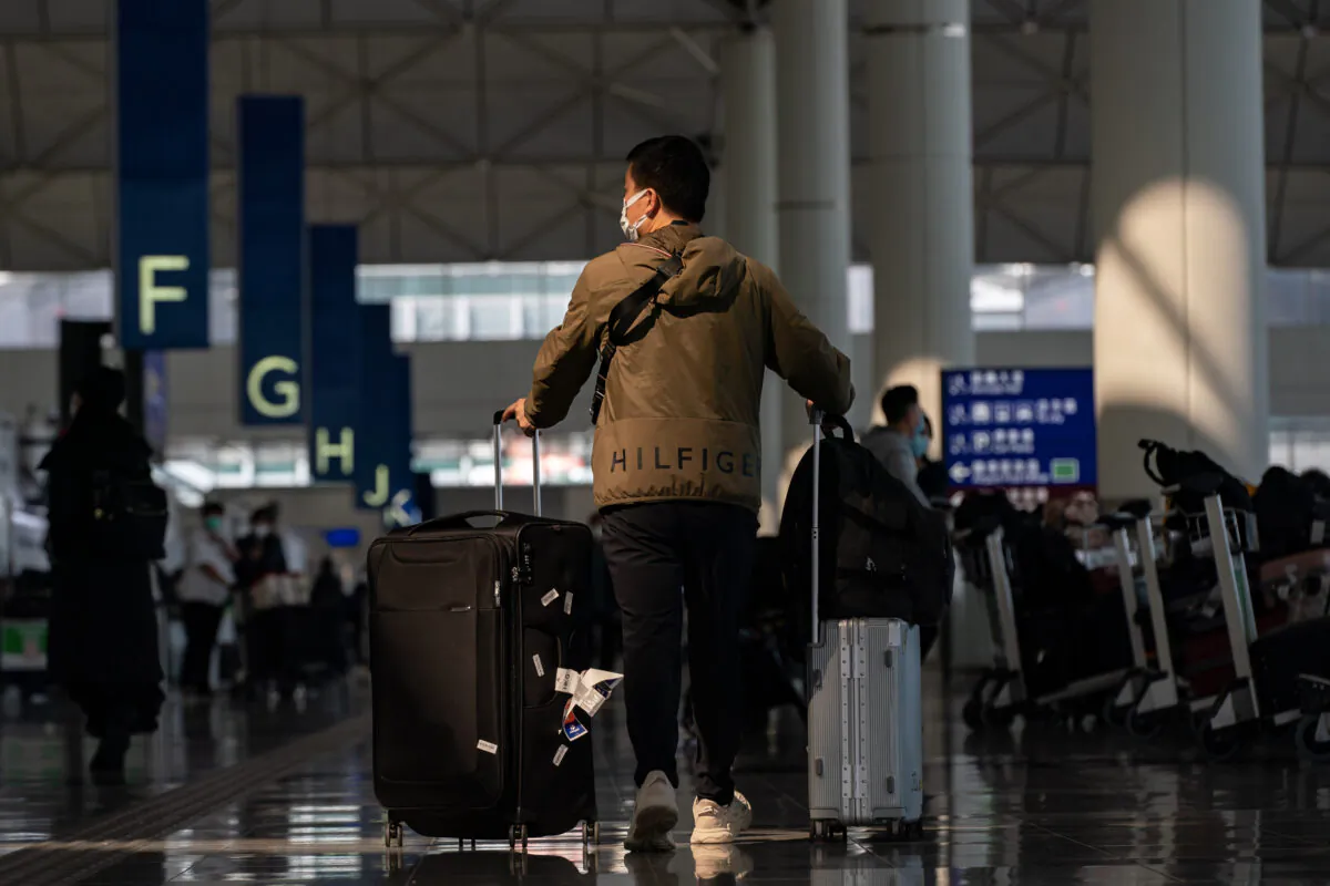 Travellers walk with their luggage at the departure hall of the Hong Kong International Airport in Hong Kong on Dec. 30, 2022. (Anthony Kwan/Getty Images)