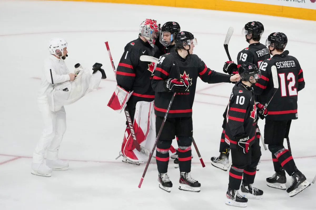 Camera operator Nathan Eides, left, records Canada celebrating a win over Sweden during IIHF World Junior Hockey Championship action in Halifax on Dec. 31, 2022. (The Canadian Press/Darren Calabrese)