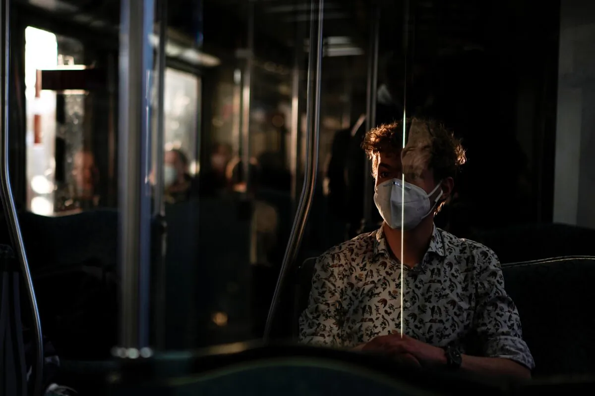A young man wearing a face mask during the COVID-19 pandemic travels on a metro in Berlin, Germany, on March 22, 2022. (Pavel Golovkin/AP Photo)