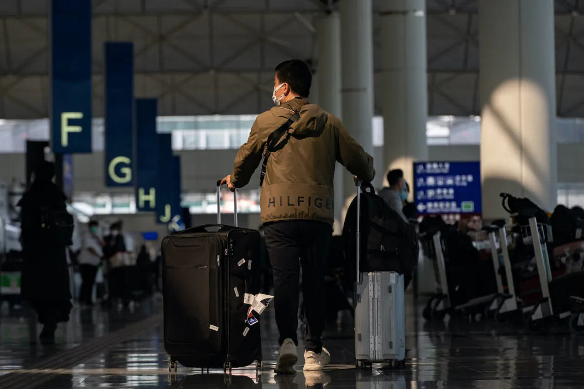 Travellers walk with their luggage at the departure hall of the Hong Kong International Airport on Dec. 30, 2022. Authorities around the world are imposing or considering curbs on travellers from China as COVID-19 case there surge following its relaxation of Zero-COVID rules. (Anthony Kwan/Getty Images)