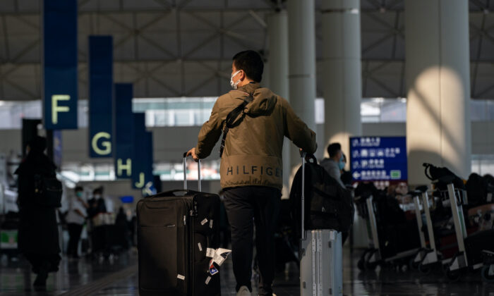 Podróżni spacerują z bagażem po hali odlotów międzynarodowego lotniska w Hongkongu 30 grudnia 2022 r. Władze na całym świecie nakładają lub rozważają ograniczenia dla podróżnych z Chin, ponieważ liczba przypadków COVID-19 wzrosła po złagodzeniu zasad Zero-COVID. (Anthony Kwan / Getty Images)