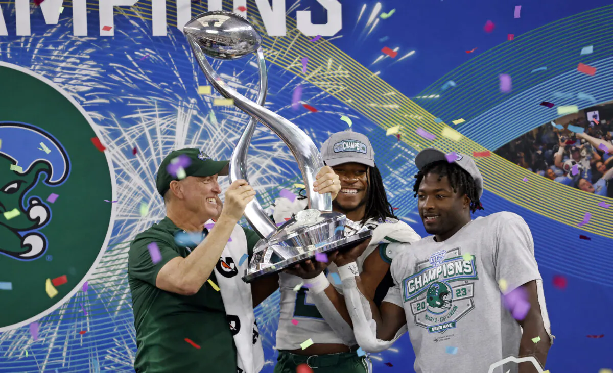 Head coach Willie Fritz of the Tulane Green Wave celebrates with players Dorian Williams (2) of the Tulane Green Wave and Tyjae Spears (22) following the teams win against the USC Trojans in the Goodyear Cotton Bowl Classic on Jan. 2, 2023 at AT&T Stadium in Arlington, Texas. (Ron Jenkins/Getty Images)