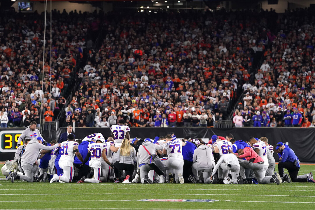 Buffalo Bills players huddle and pray after teammate Damar Hamlin #3 collapsed on the field after making a tackle against the Cincinnati Bengals during the first quarter at Paycor Stadium in Cincinnati, Ohio, on Jan. 2, 2023. (Dylan Buell/Getty Images)