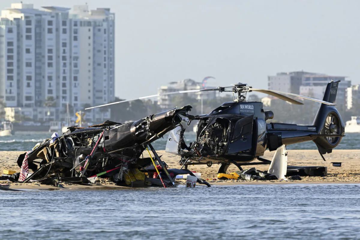 Two cashed helicopters sit on the sand at a collision scene near Seaworld, on the Gold Coast, Australia, on Jan. 2, 2023. (Dave Hunt/AAP Image via AP)