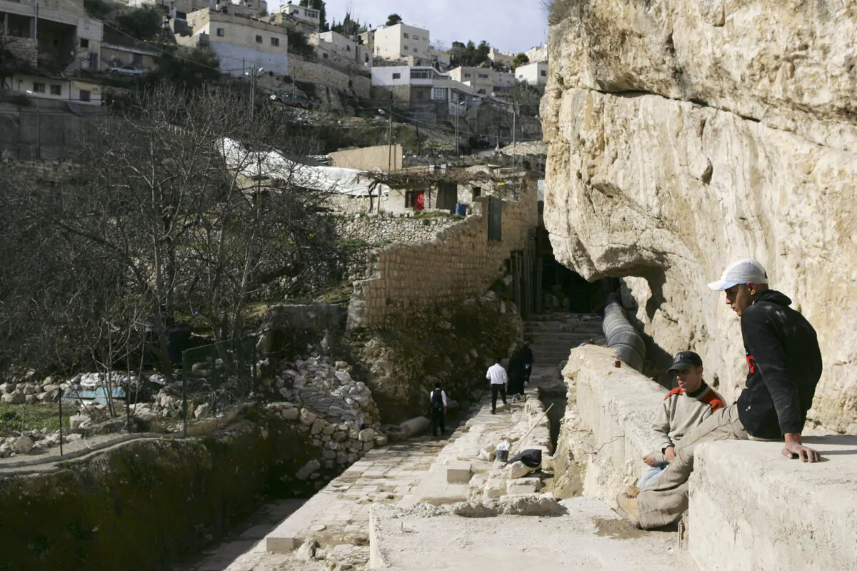 Palestinian workers take a break from cleaning the Siloam spring, used by Jewish pilgrims during the Second Temple period, below the walls of the Old City of Jerusalem on January 28, 2007. (David Silverman/Getty Images)