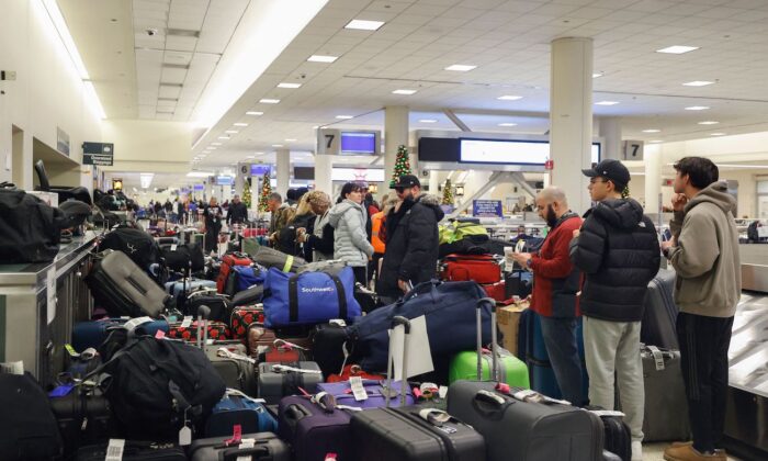 Stranded Southwest Airlines passengers looks for their luggage in the baggage claim area at Chicago Midway International Airport in Chicago, Illinois, on Dec. 28, 2022. (Kamil Krzaczynski/AFP via Getty Images)