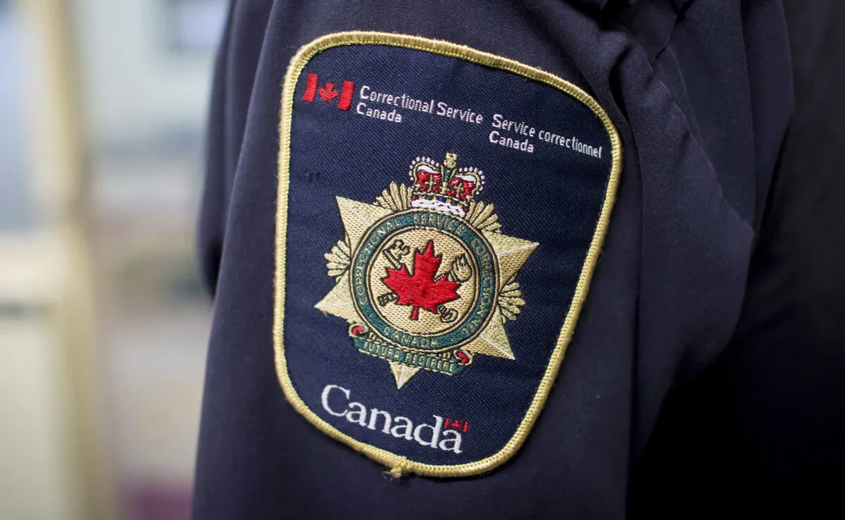 Patches are seen on the arm and shoulder of a corrections officer, on Oct. 26, 2017. (Darryl Dyck/The Canadian Press)