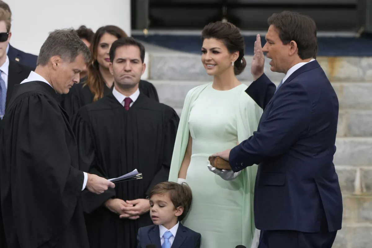 Florida Gov. Ron DeSantis, right, is sworn by Florida Supreme Court Chief Justice Carlos Muniz, left, to begin his second term during an inauguration ceremony outside the Old Capitol Tuesday in Tallahassee, Fla., on Jan. 3, 2023. Looking on is DeSantis' wife Casey, second from right, and their son Mason. (AP Photo/Lynne Sladky)